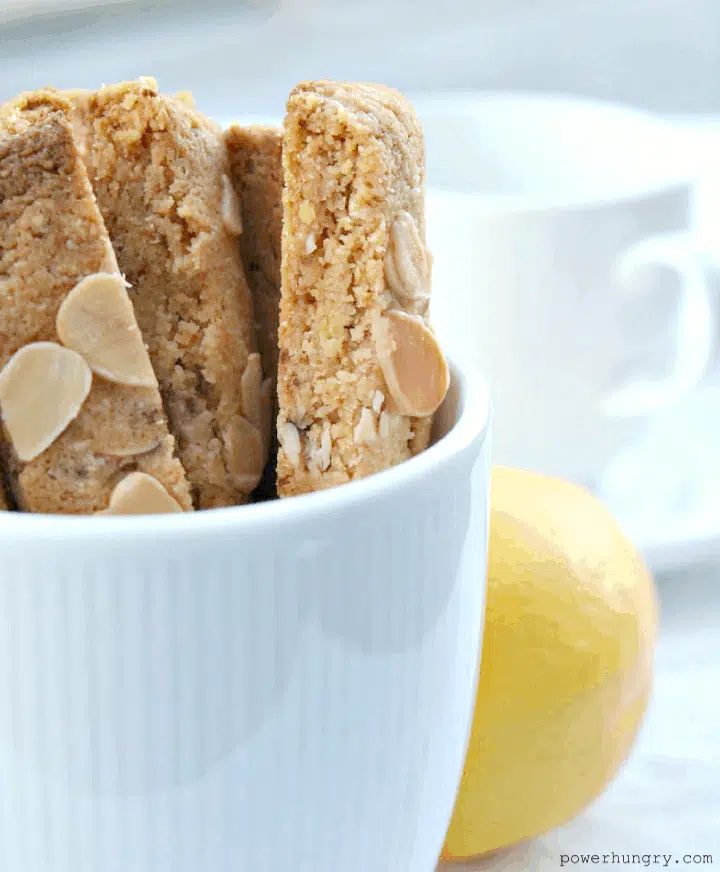 four almond coconut flour biscotti upright in a white coffee cup