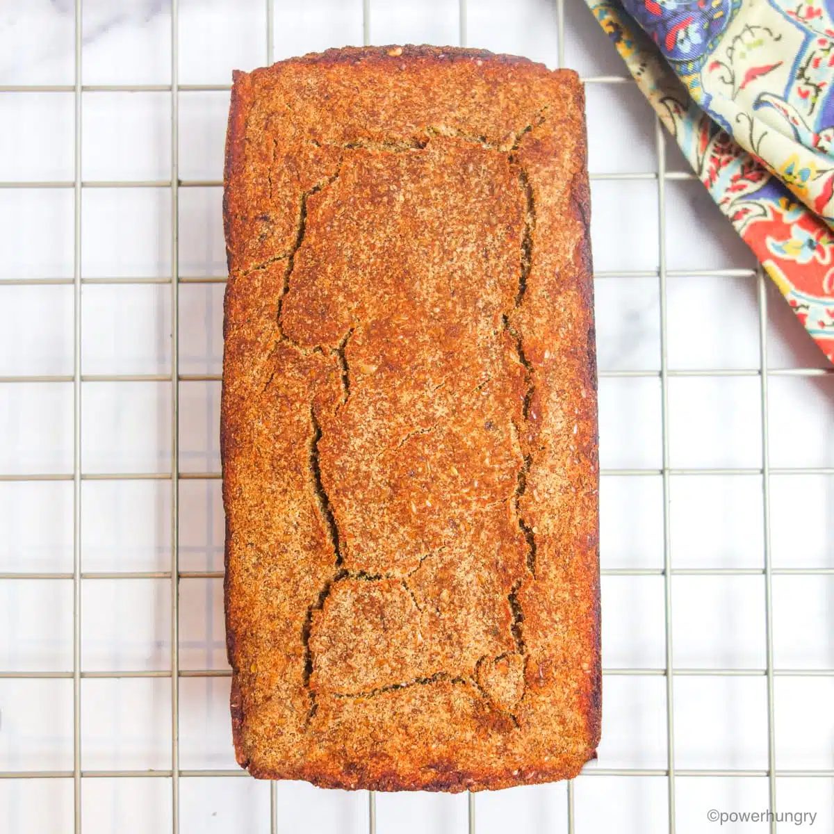 overhead shot of baked banana bread on a gold large grid cooling rack