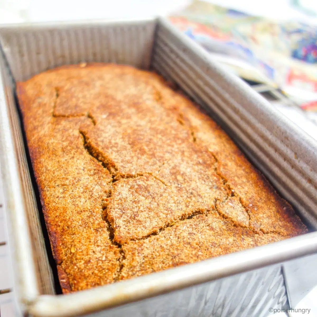 baked coconut flour banana bread in a metal baking pan on top of a cooling rack