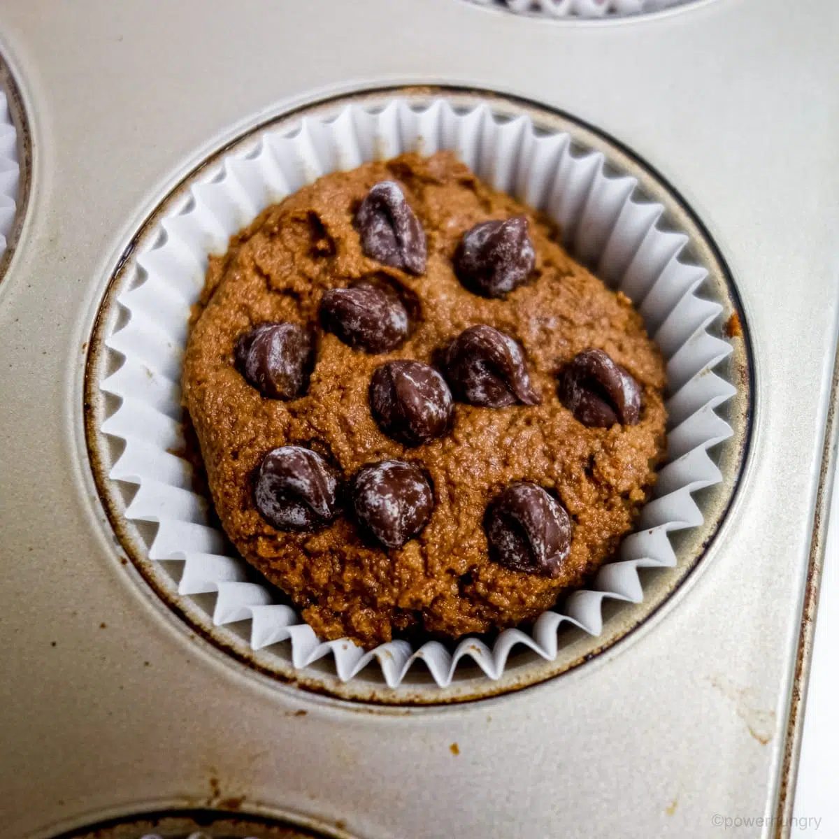 unbaked chocolate coconut flour cupcake with chocolate chips pressed into the top