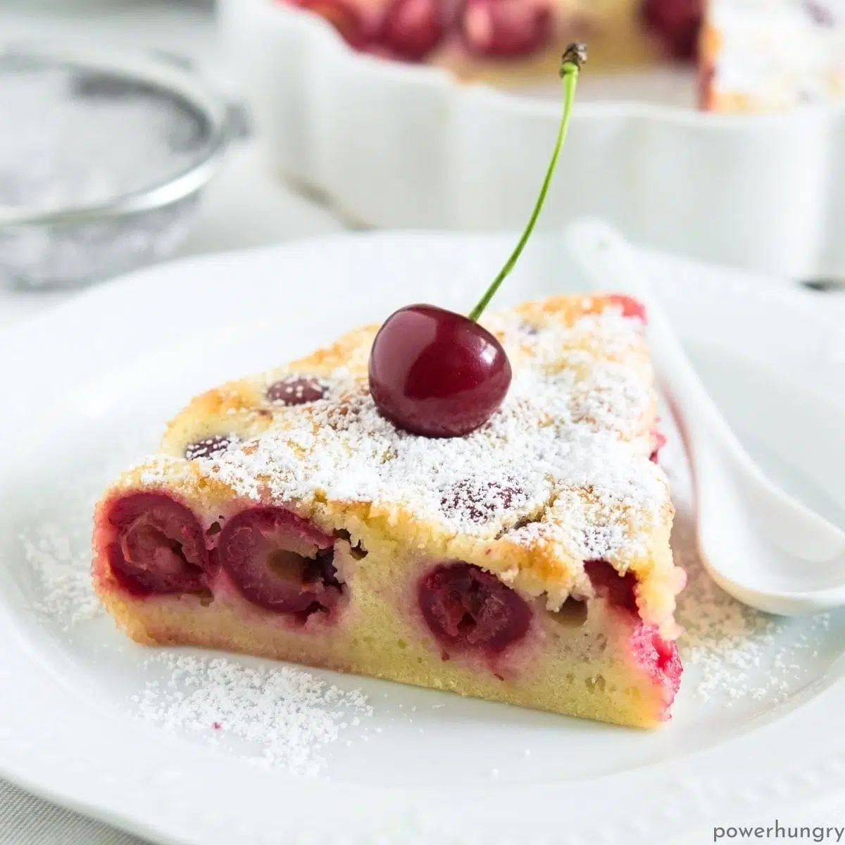 a slice of vegan coconut flour clafouti on a white plate