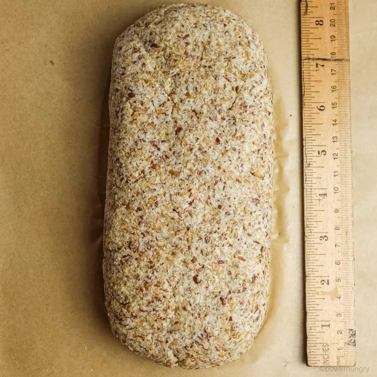 Unbaked dough for coconut flour flax bread on a parchment lined baking sheet