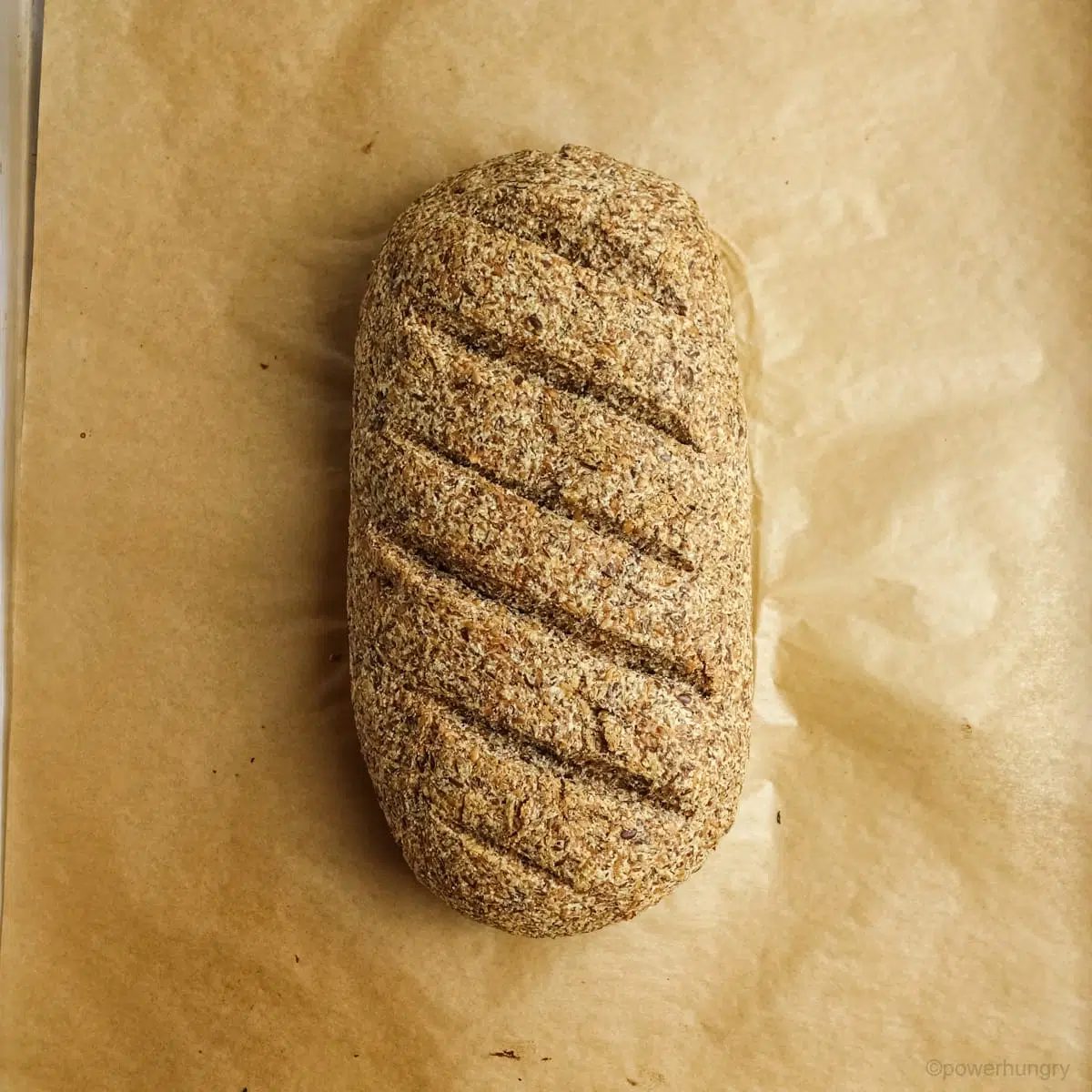 Coconut flour flax bread on a parchment lined baking sheet.