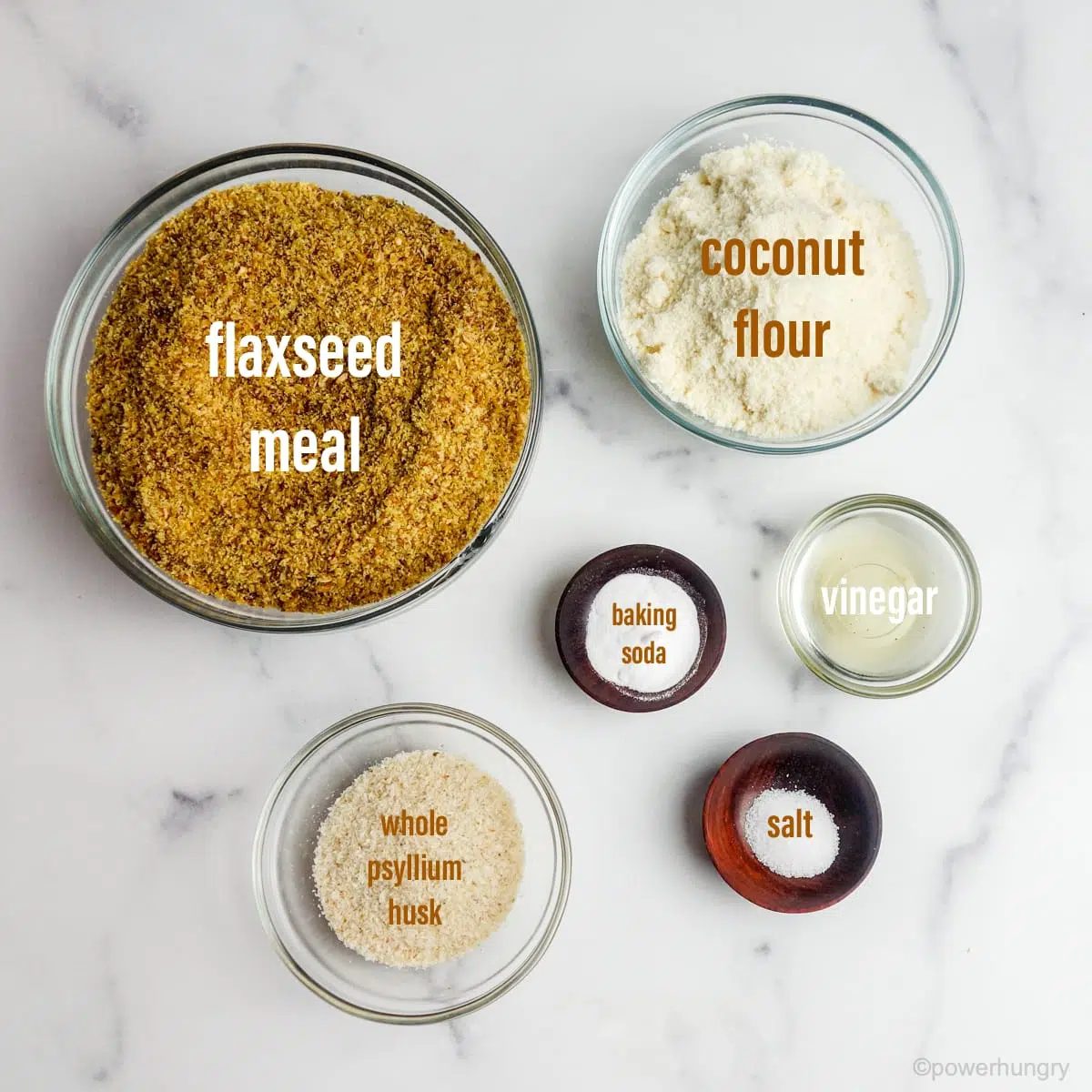 Glass bowls filled with coconut flour flax bread ingredients