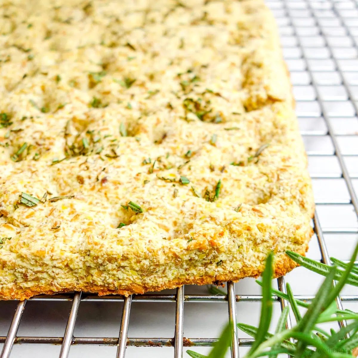 Close up of the corner edge of coconut flour focaccia on a silver cooling rack