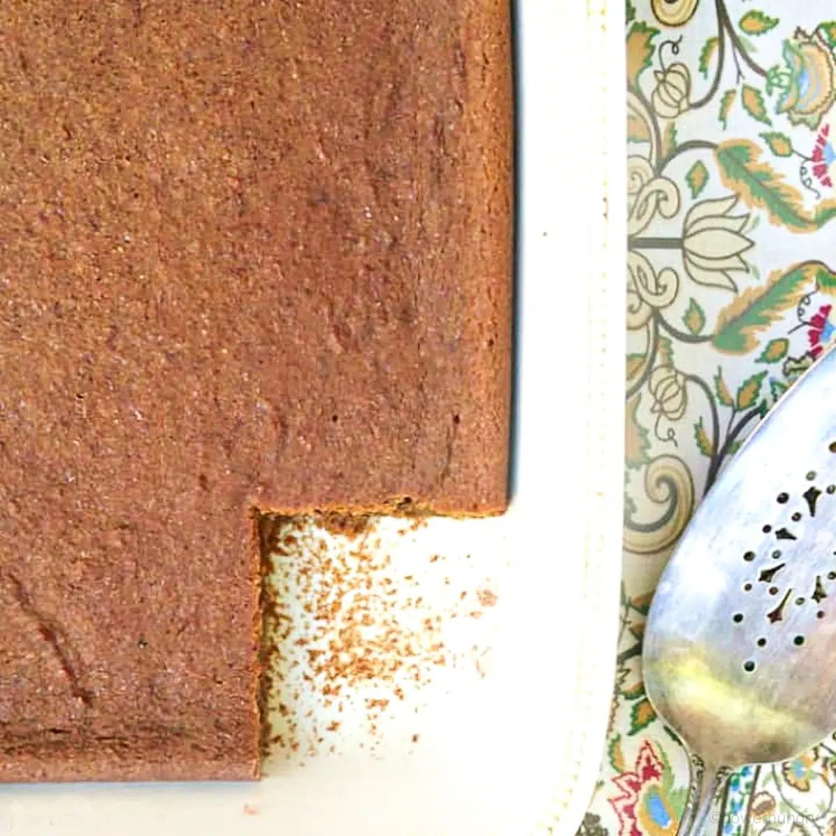 vegan oil free gingerbread blondies in a white dish with a silver serving spatula alongside