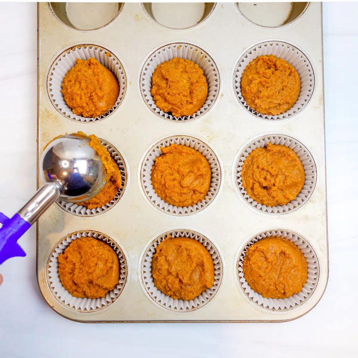 coconut flour pumpkin muffin batter divided between 9 muffin cups