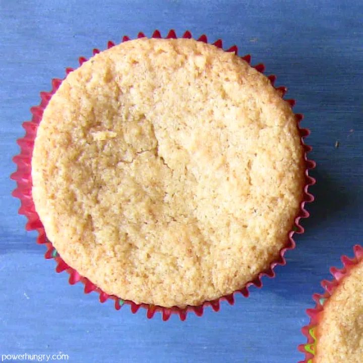 overhead shot of a vanilla coconut flour vegan cupcake on a blue background