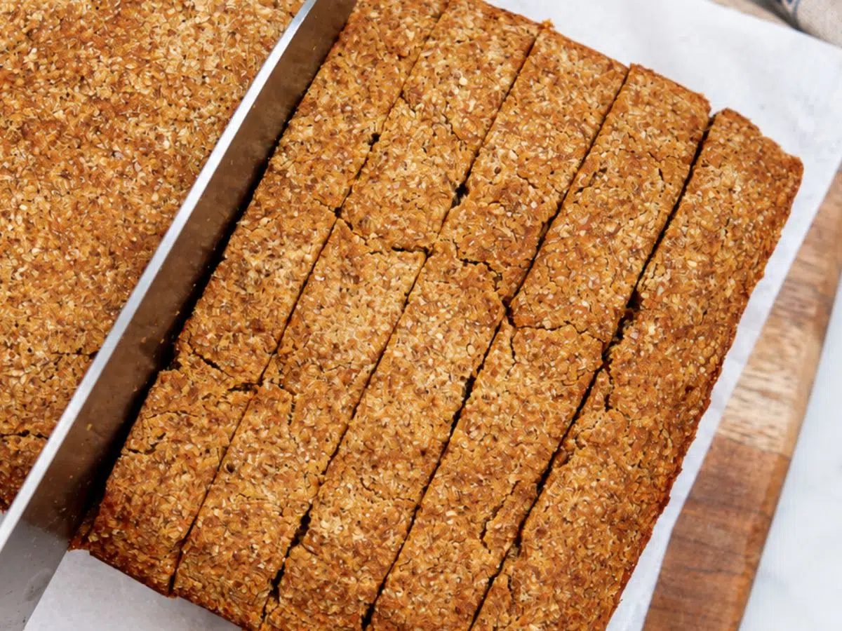 coconut flour vegan pumpkin bread being sliced on cutting board