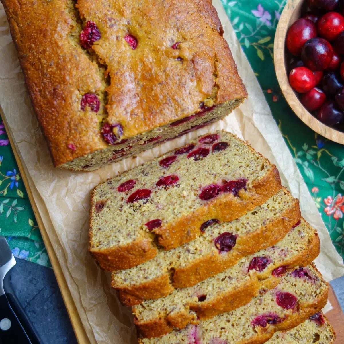 slices of cranberry orange chickpea bread on a wood cutting board