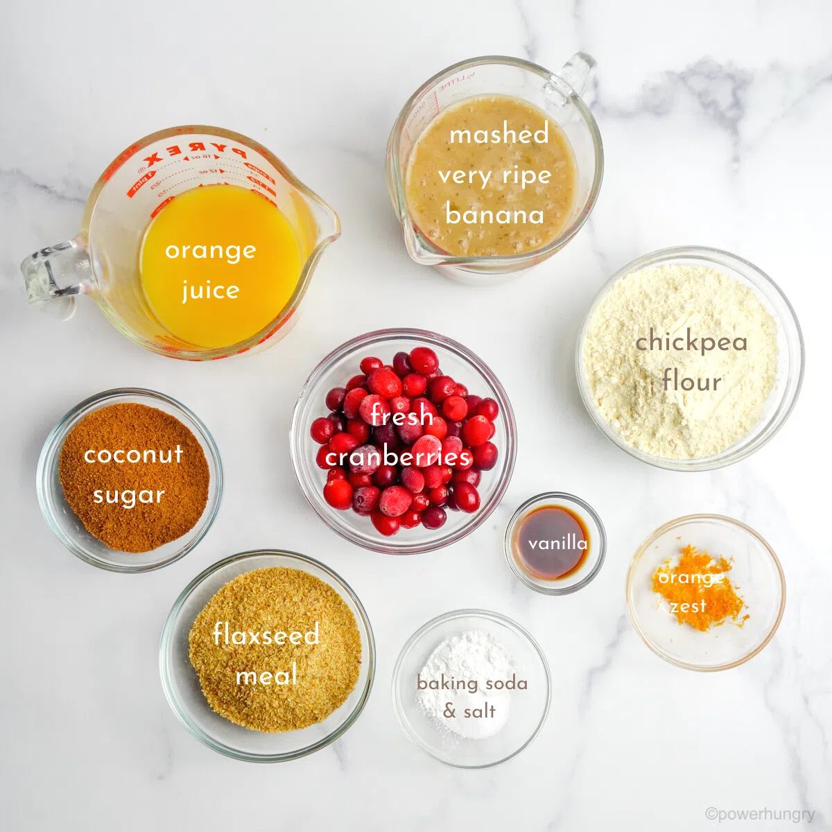 ingredients for cranberry orange bread on a marble countertop