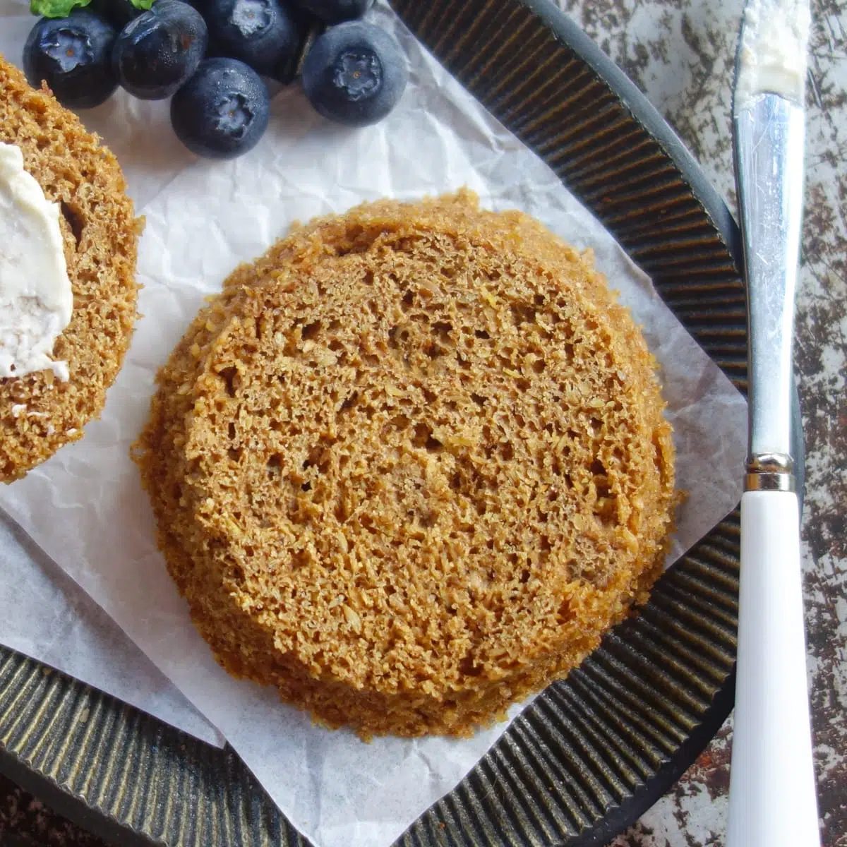 close up of half of a microwave single serving flax muffin on a metal plate