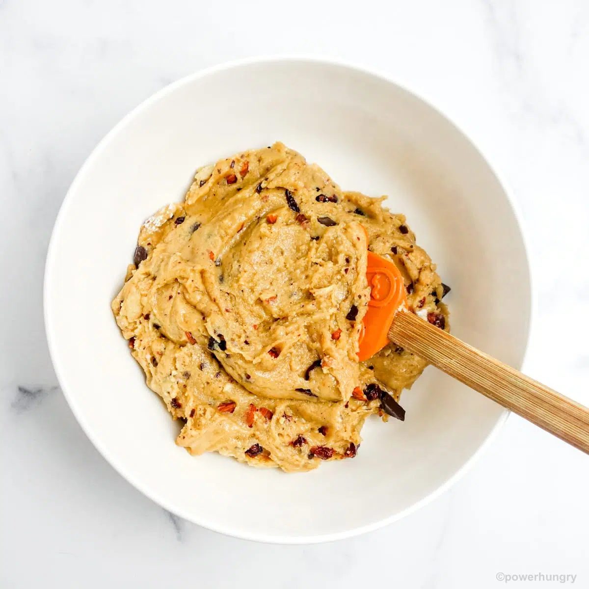 white bowl filled with biscotti dough and a wood spatula