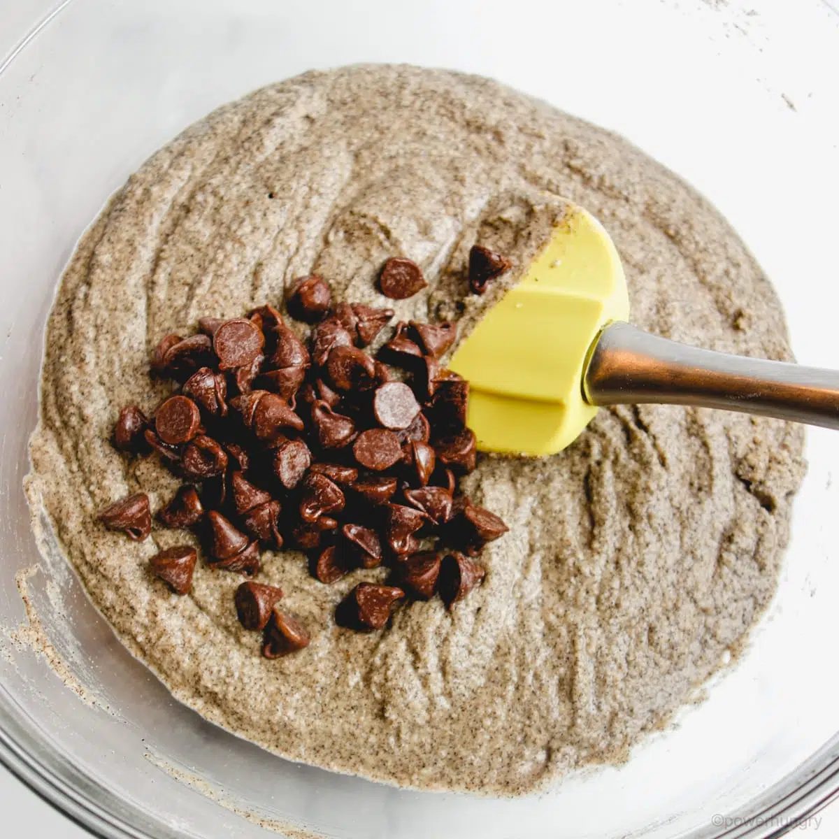 buckwheat muffin batter in a glass bowl with chocolate chips added