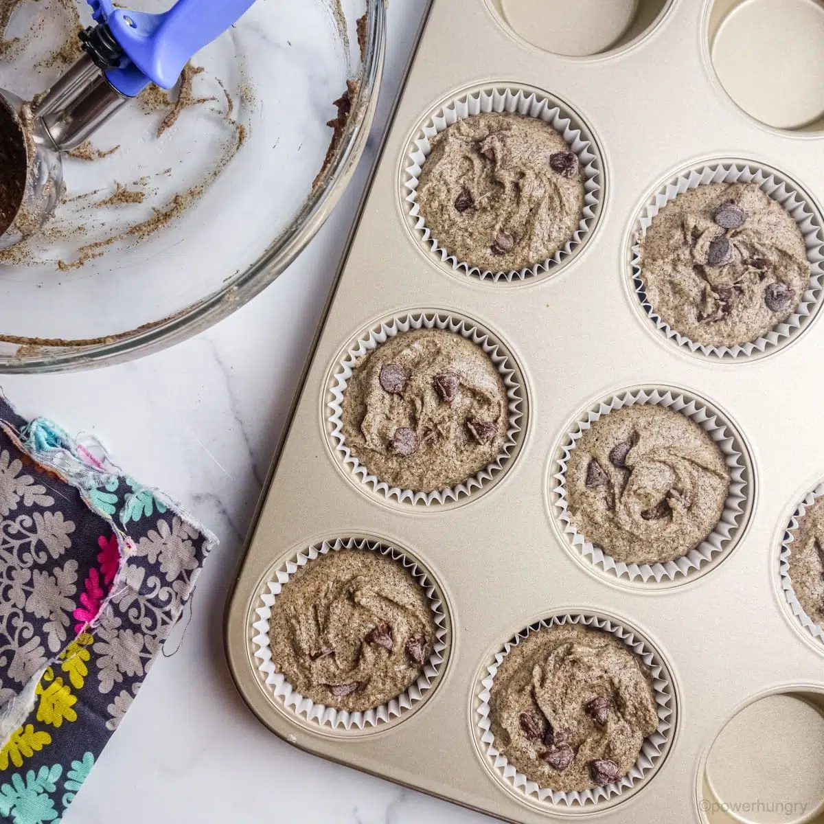 buckwheat flour muffin batter portioned into white paper lined muffin cups