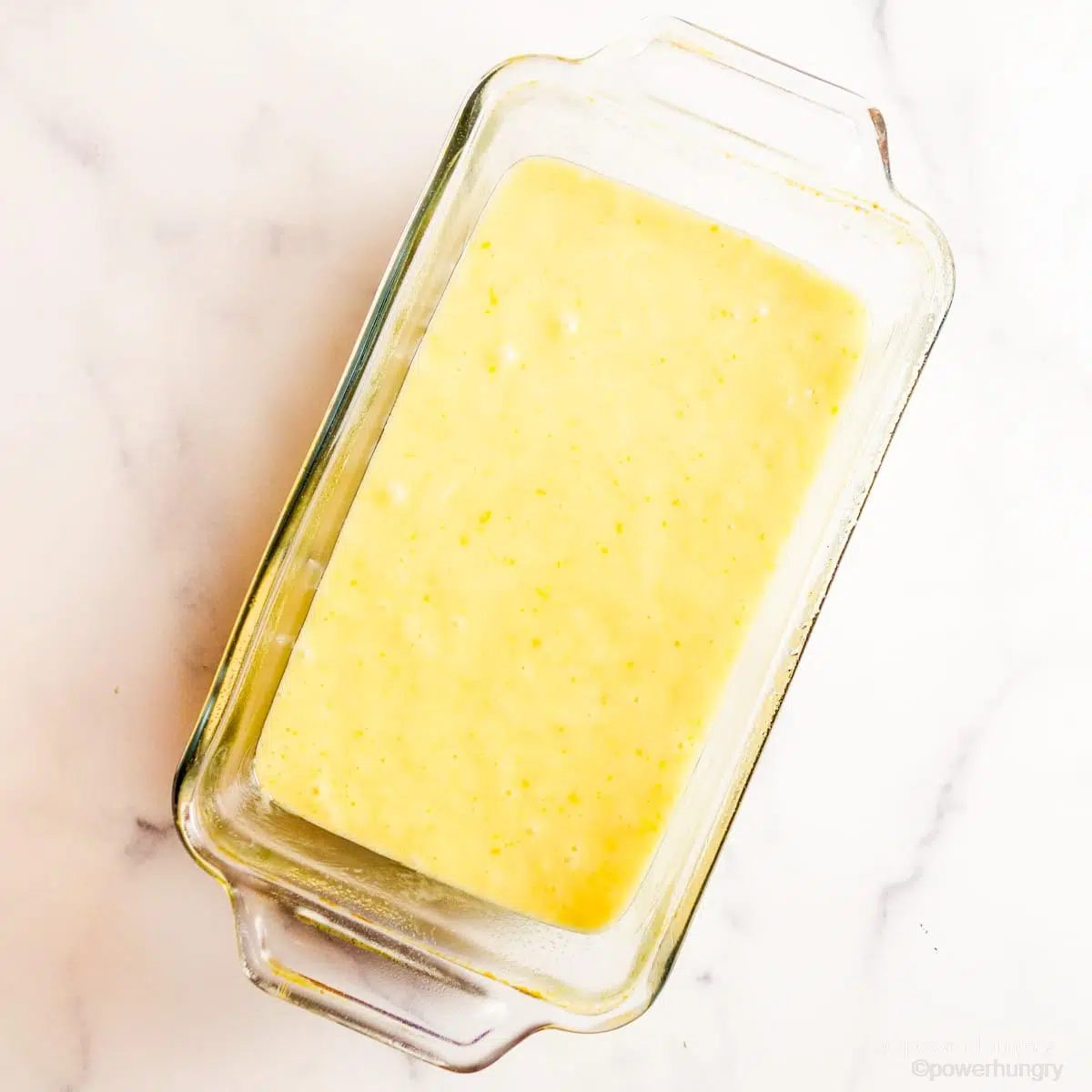 emon loaf batter in a clear glass loaf pan