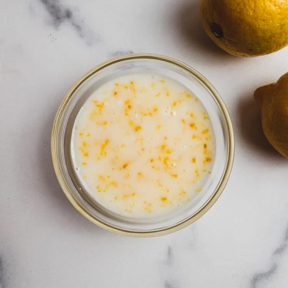 cashew lemon glaze for lemon loaf, all in a small glass bowl
