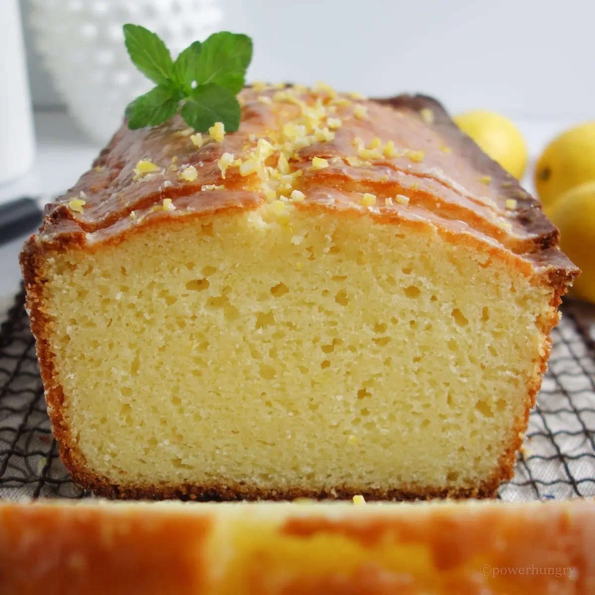 close up of a sliced lemon loaf on a cooling rack