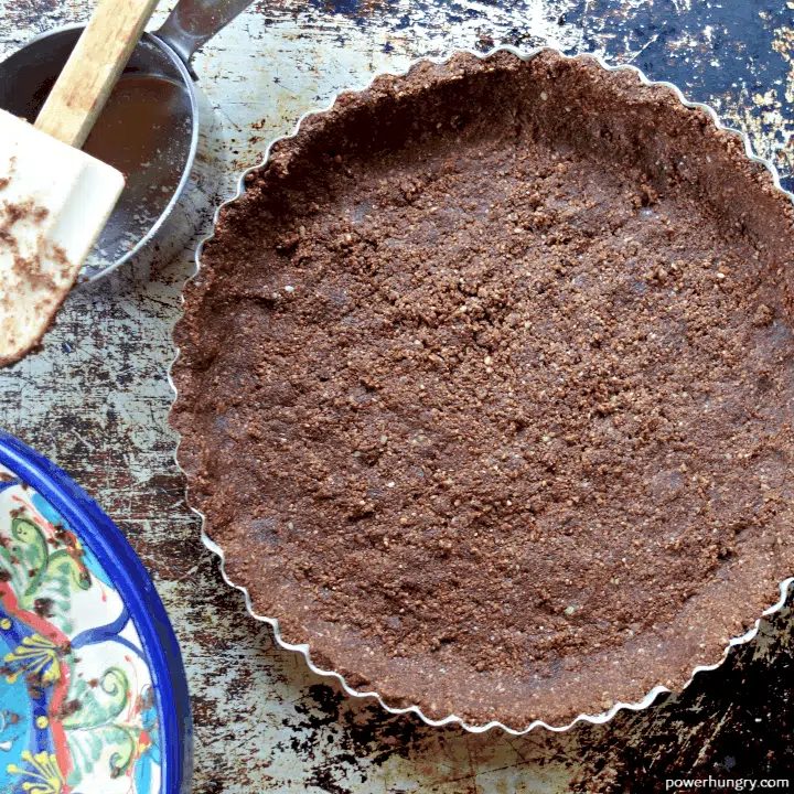 overhead shot of almond flour chocolate crust in a tart pan