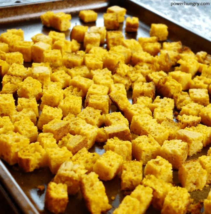 cubes of toasted chickpea flour cornbread on a baking sheet