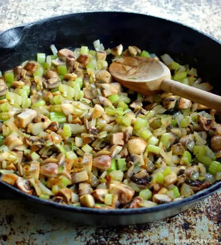sautéed onions mushrooms and celery in a cast iron skillet