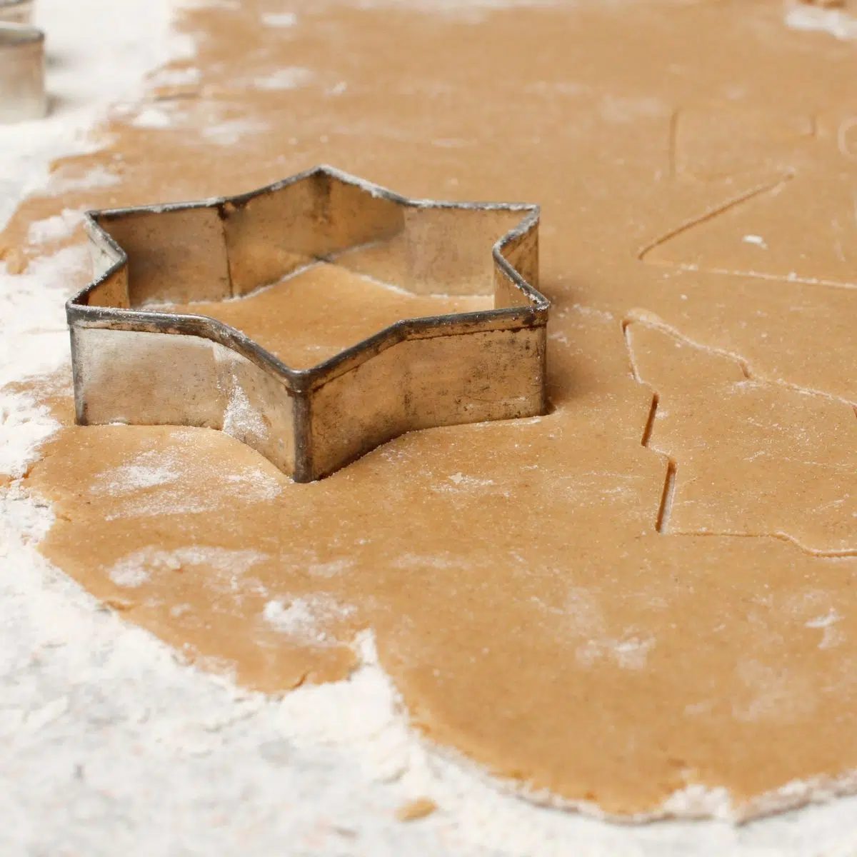 oat flour dough getting cut with a star cookie cutter
