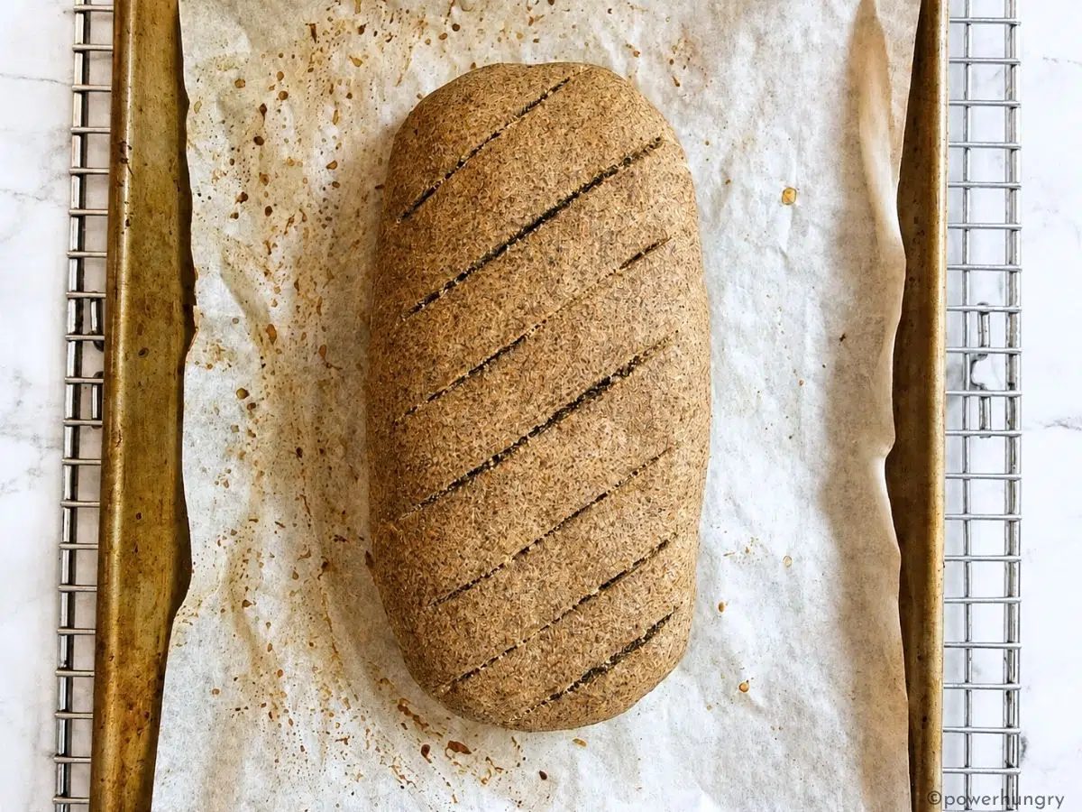 baked vegan oat fiber bread on a baking sheet, cooling