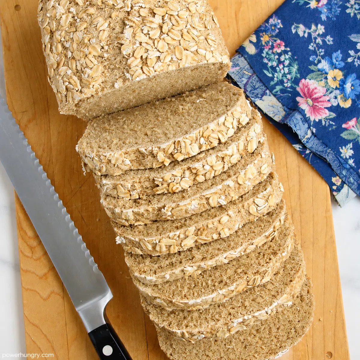overhead shot of a hero image of vegan gluten-free oat sandwich bread on a wood cutting board
