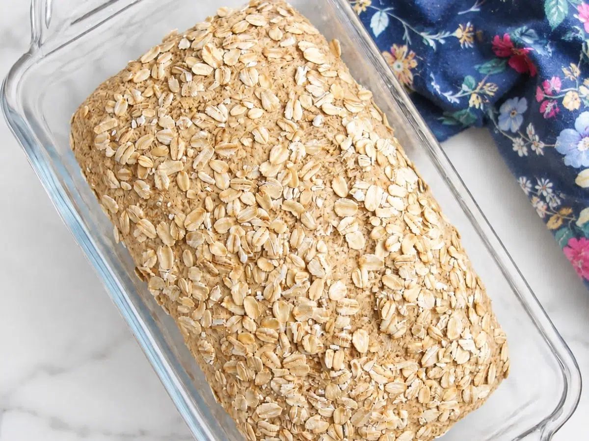 baked loaf of vegan gluten-free vegan oat sandwich bread, with a blue floral napkin