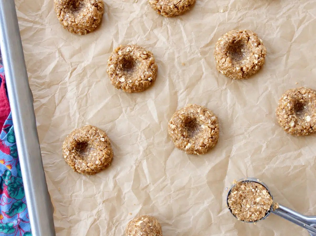 shaping and making thumbprint impressions on vegan oat flour thumbprint cookies