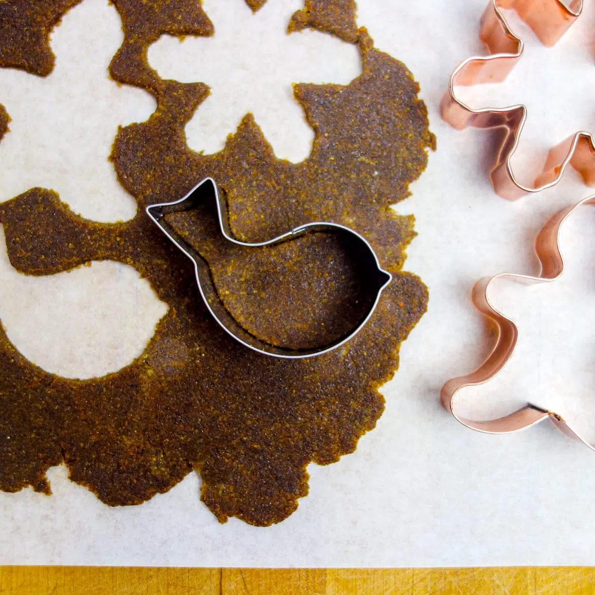 gingerbread cookies getting cut out with metal cutters