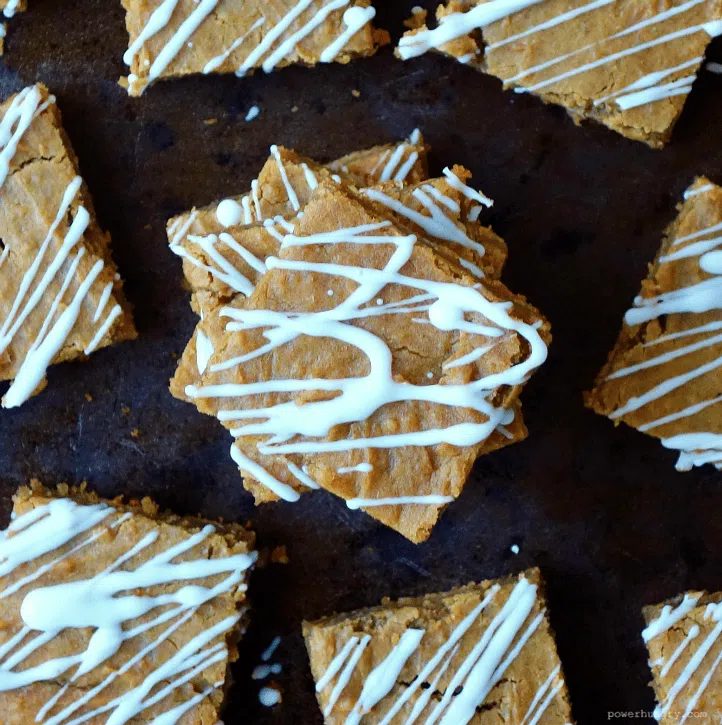 Vegan gingerbread chickpea blondies, drizzled with white chocolate, on a baking sheet