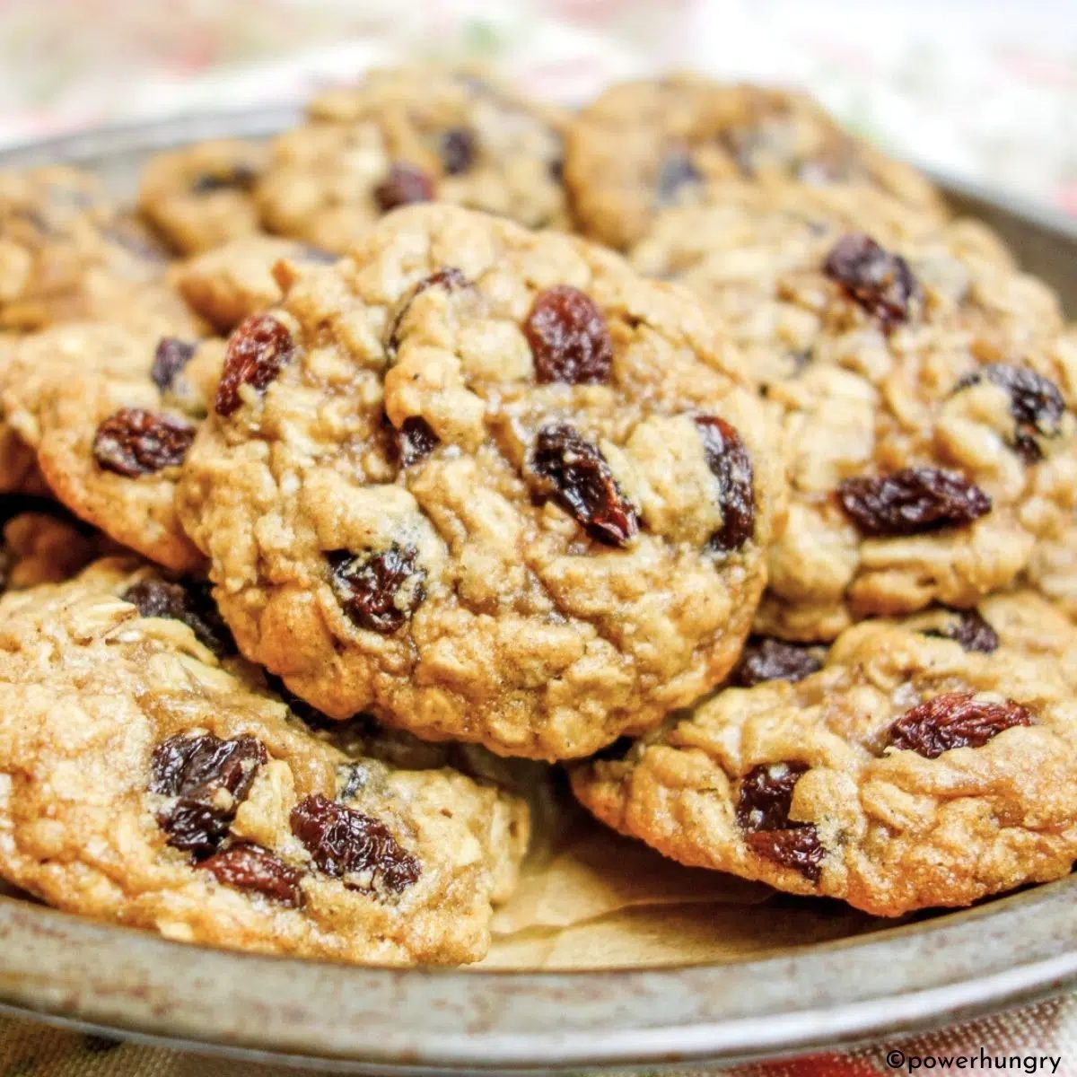 stacked oatmeal raisin cookies in a tin dish