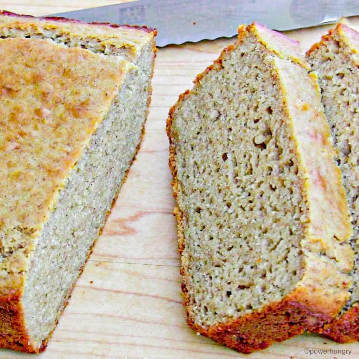 slices of quinoa banana bread on a light wood cutting board