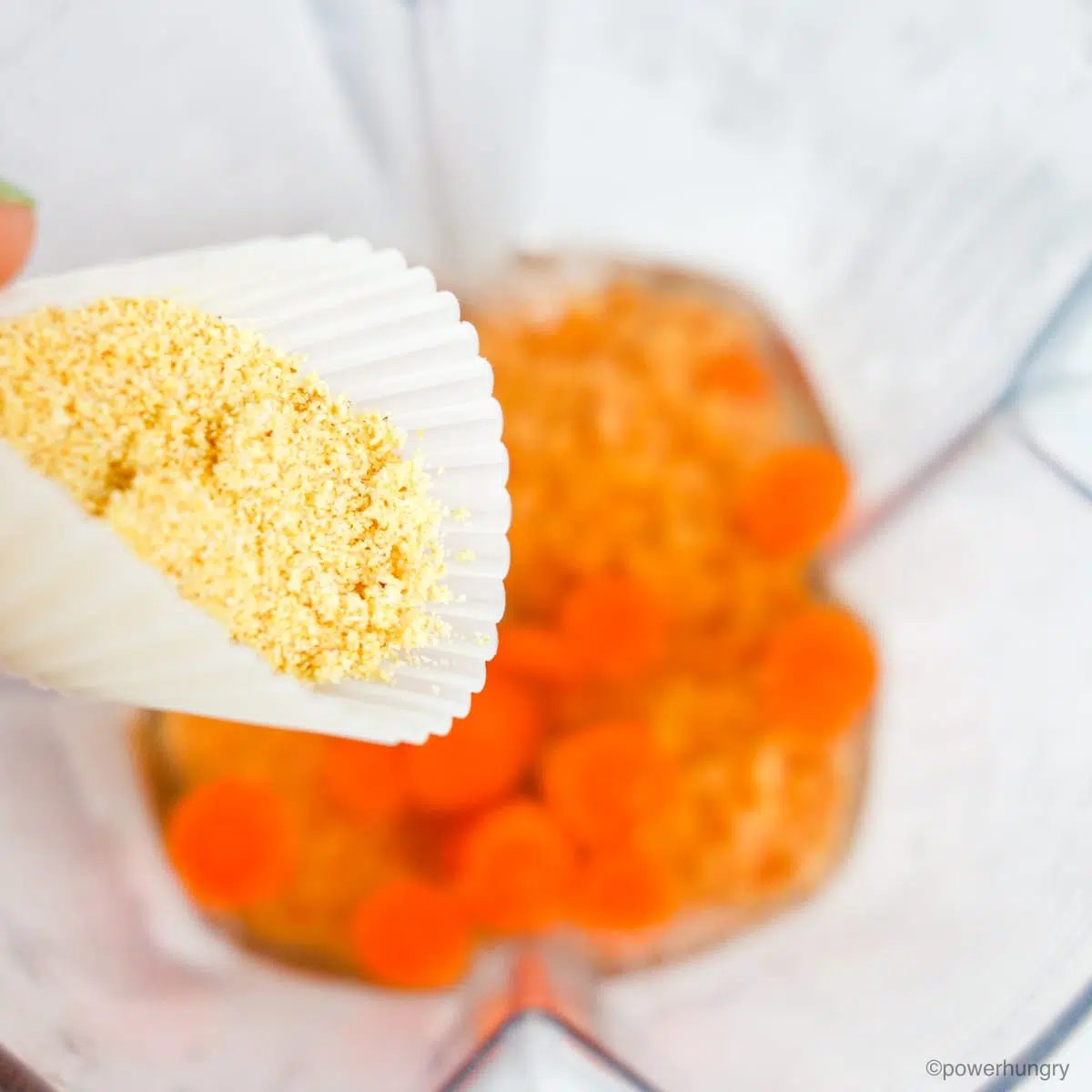 close up of garlic powder and onion powder in a white container above a mixture of lentils and carrots