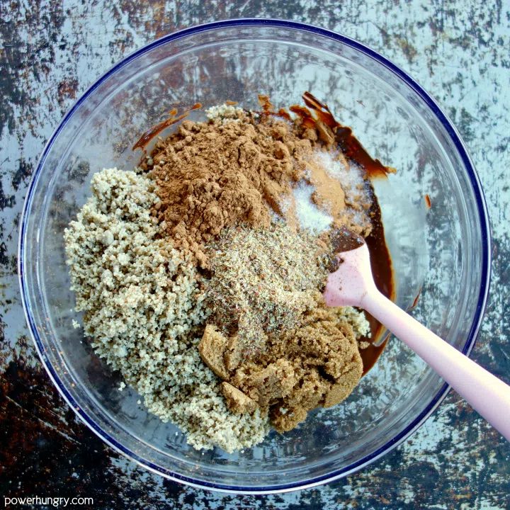 the dry ingredients for vegan sunflower chocolate crinkles added to bowl of melted chocolate