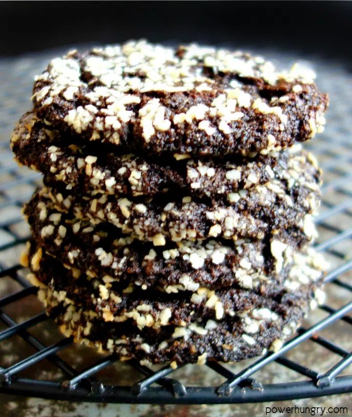 a stack of 6 chocolate crinkle cookies on a black cooling rack.