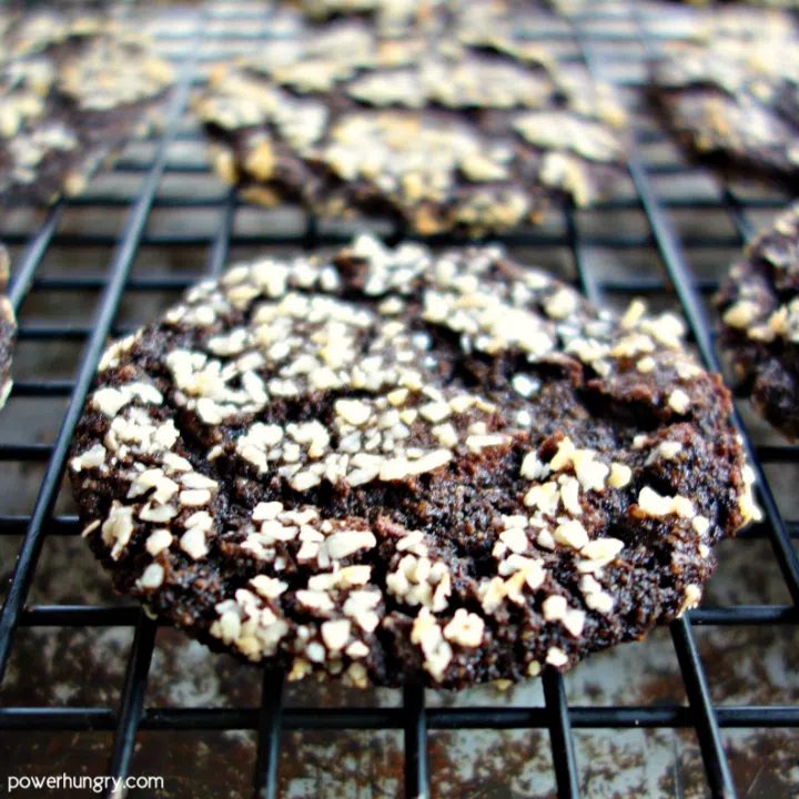 baked vegan chocolate sunflower crinkle cookie on a black wire cooling rack