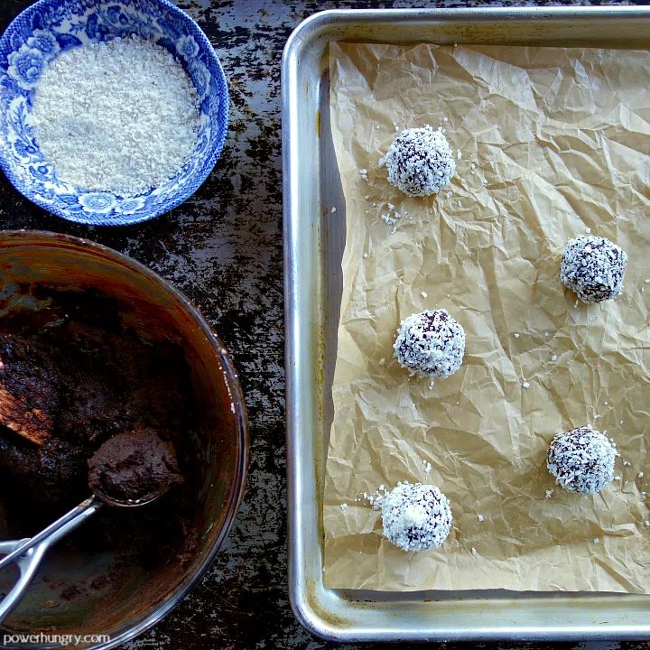 chocolate cookie dough being scooped, rolled, and place on a baking sheet
