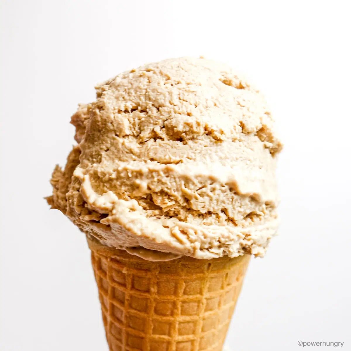 a scoop of sunflower seed vanilla ice cream on a sugar cone