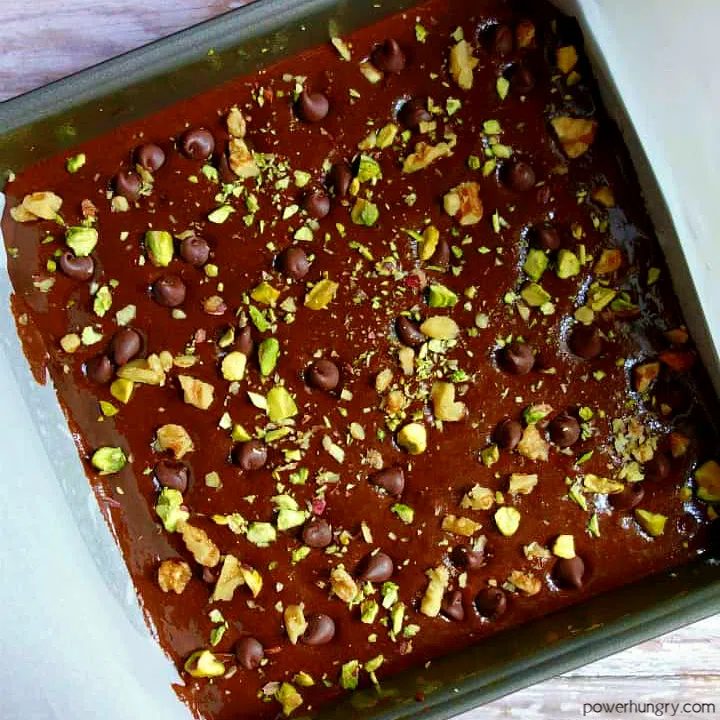 unbaked tigernut brownie batter in a metal baking pan lined with parchment paper