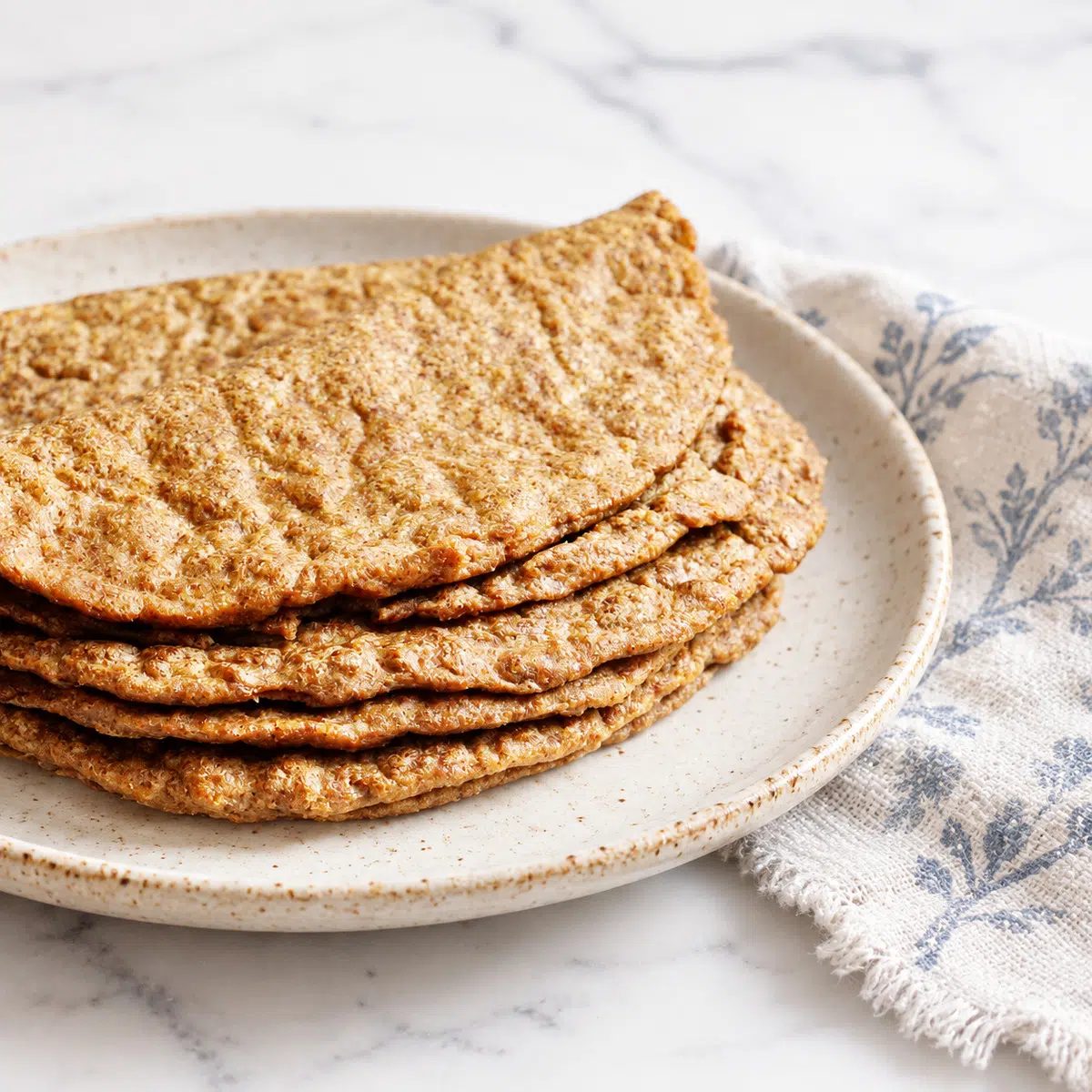 flaxseed tortillas on a plate with top one folded