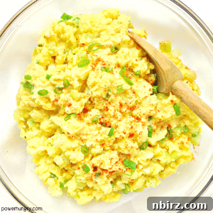 A vibrant and appetizing chickpea flour egg-free salad presented beautifully in a clear glass bowl, set against a pristine white background, inviting a delightful culinary experience.