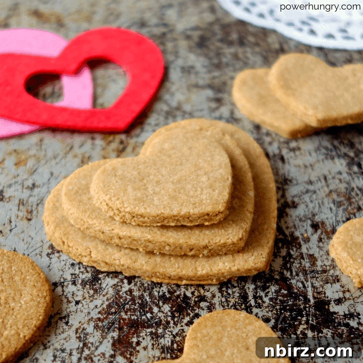 Effortless Two-Ingredient Almond Flour Cut-Out Cookies Vegan Keto Option 2 Heart-shaped 2-ingredient almond flour cut-out cookies elegantly arranged on an aged metal background, symbolizing love and the simple pleasure of baking.