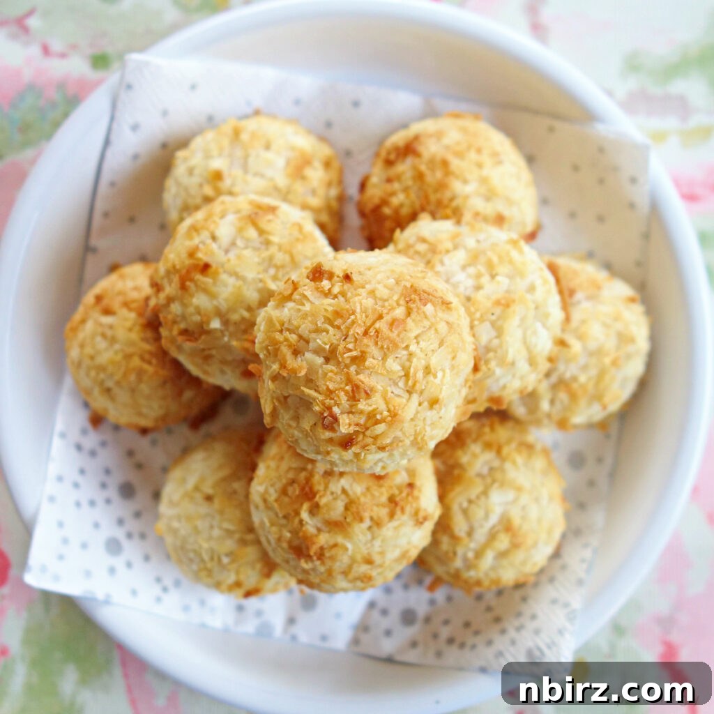 Irresistible Vegan Coconut Macaroons Gluten-Free and Oil-Free 2 A beautiful pile of golden-brown vegan gluten-free macaroons on a white dish, showcasing their crisp texture and delicious appeal.