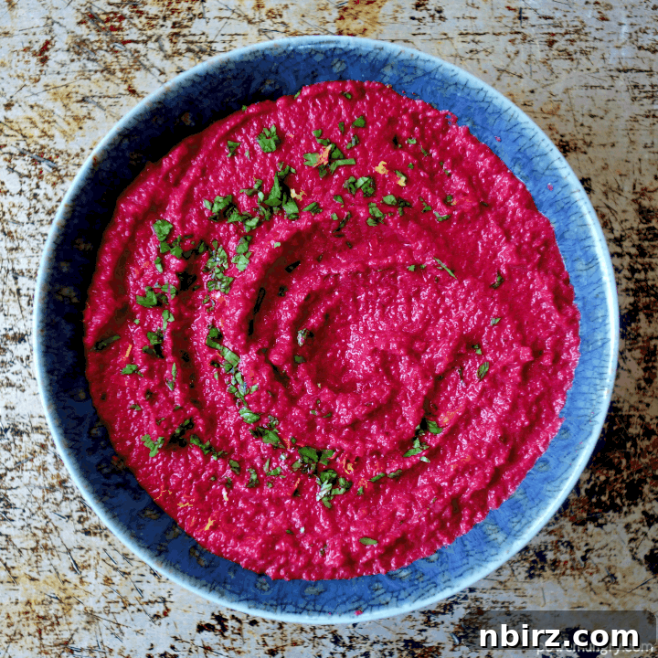 Velvety Beet and Toasted Pepita Dip 10 An exquisite overhead shot of the healthy beet and toasted pepita dip, beautifully presented in a rustic blue pottery bowl, garnished and ready for tasting.