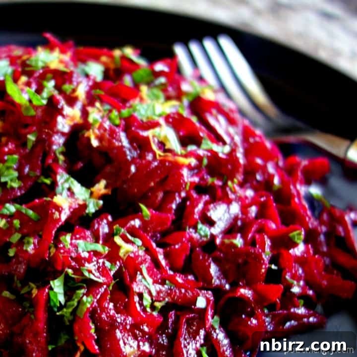 close-up of fresh beet salad with lemon & mint on a slate plate with a fork alongside