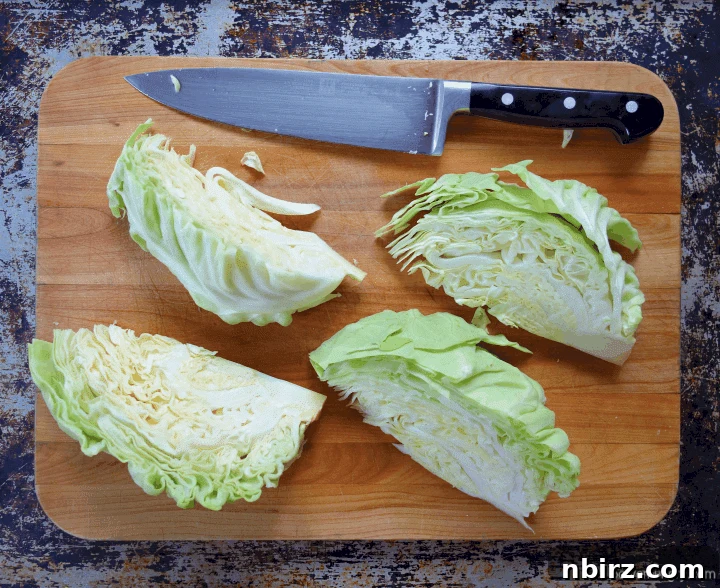 Caboodles: One-Ingredient Vegan Keto Steamed Cabbage Noodles 4 A meticulously quartered head of vibrant green cabbage rests on a natural wooden cutting board, ready for the next step in preparing healthy cabbage noodles.