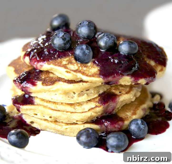 A beautifully presented stack of fluffy chickpea flour pancakes on a white plate, showcasing their inviting texture.