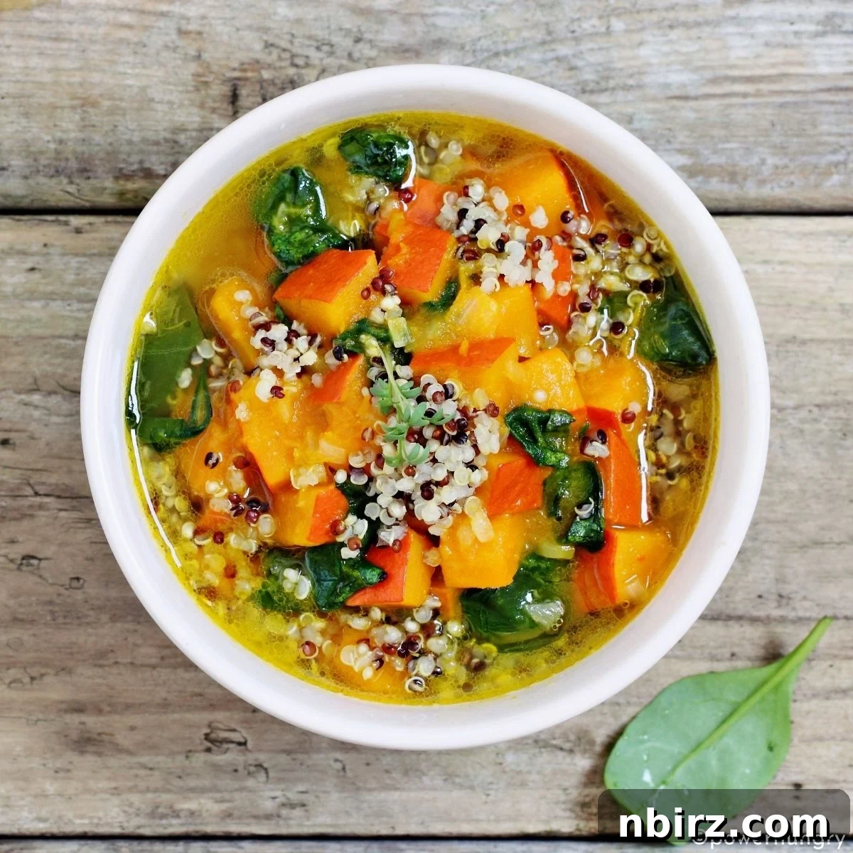 Wholesome Vegan Gluten Free Oil Free Quinoa Minestrone 2 A vibrant, steaming bowl of vegan quinoa minestrone, rich in vegetables, photographed in a clean white bowl.